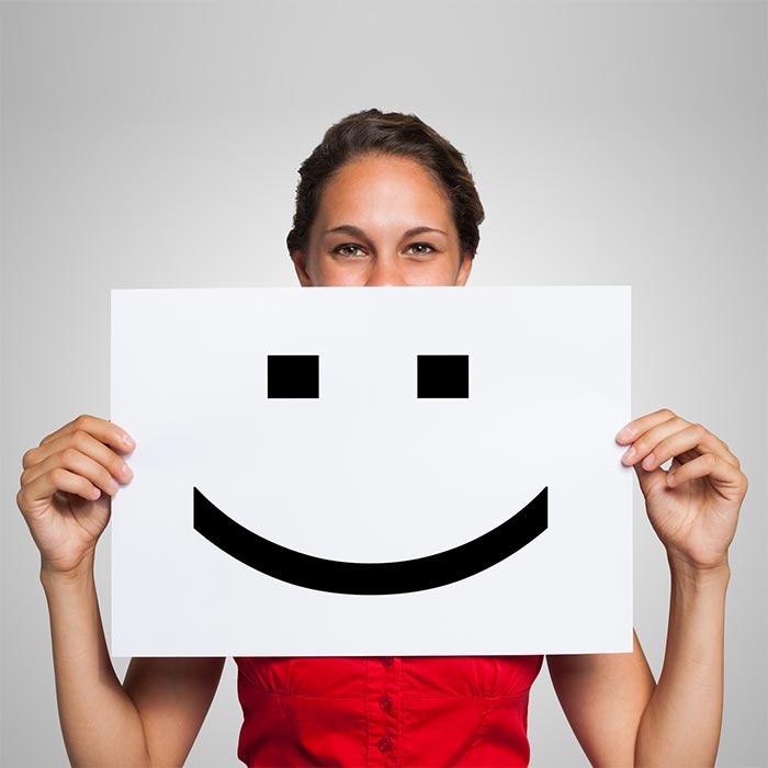 Happy employee holding a sign with smiley face